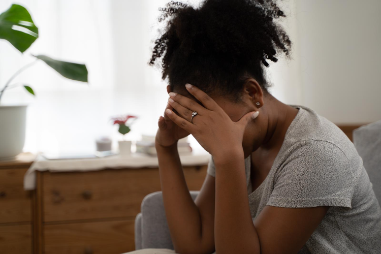 A woman covering her face due to fatigue