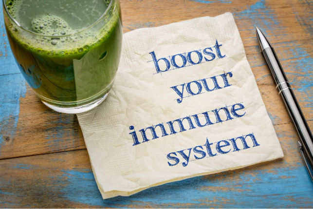 A close-up of a green drink and a napkin that reads "boost your immune system," suggesting health and wellness.
