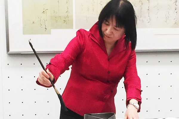 日書展会場で席上揮毫をする荒井先生と、観客の皆さん2