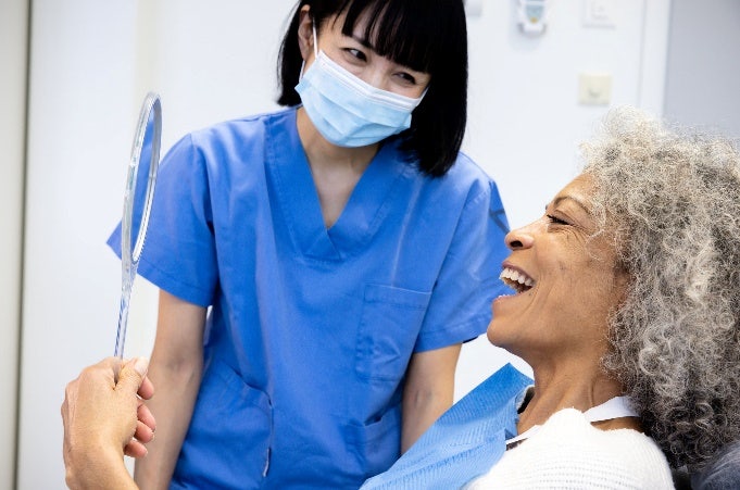 OCP-Patient-grey-hair-smiling-with-hand-mirror.jpg