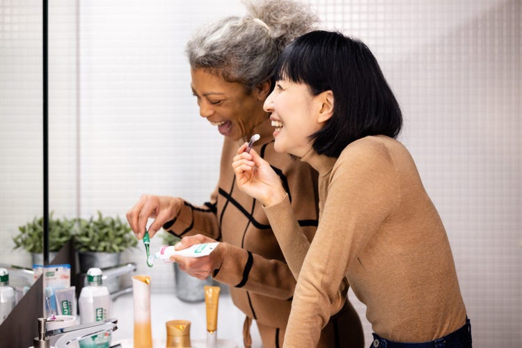 Sunstar Consumer Oral Care Products displayed on bathroom counter and in use by two women.