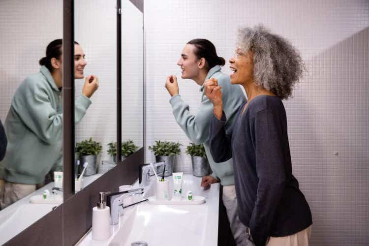 young boy and older woman brushing their teeth