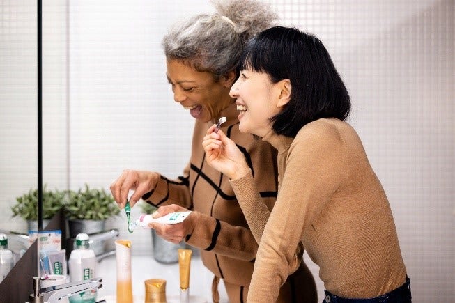 Sunstar Consumer Oral Care Products displayed on bathroom counter and in use by two women.