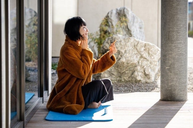 Woman applying Sunstar beauty product during skincare routine.